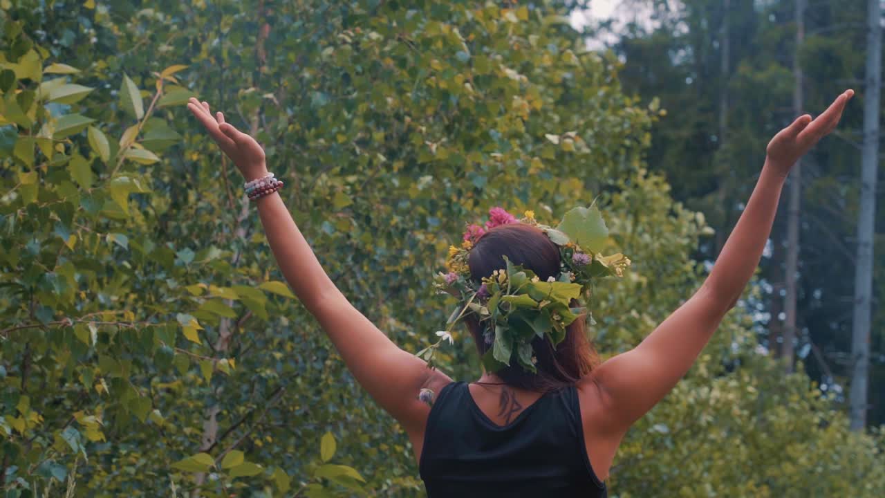 Woman Wearing Black Dress - Flower Crown Walks into Forest with Hands in Air then spins between trees