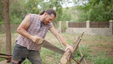 man sawing a log outdoors