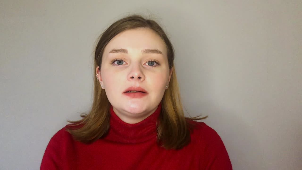 молодая студентка здоровается и говорит прямо в камеру