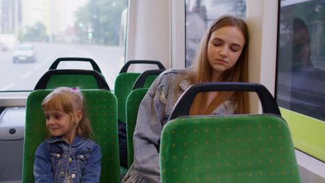 Erschöpfte-Mutter-Schläft-Ein-Und-Verpasst-Haltestelle-In-Der-Straßenbahn,-Kind-Tochter-Wacht-Müde-Schläfrige-Frau-Auf