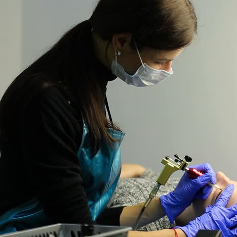 mujer haciendo un tatuaje de cejas