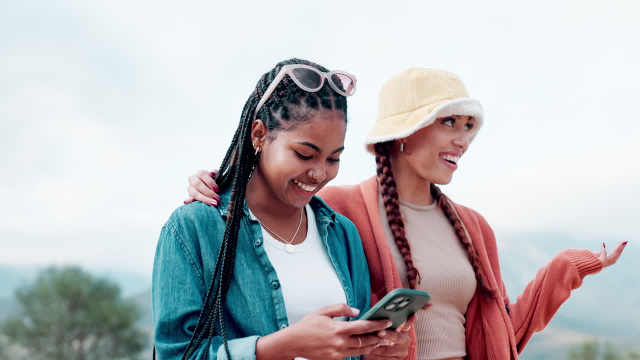 Two smiling women looking at a phone