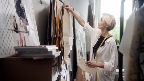mujer sastre eligiendo piezas de ropa en el taller de costura 1