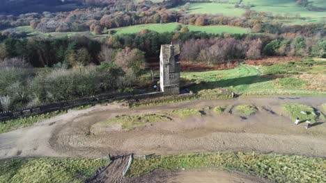 historic creepy fairy tale rivington pigeon tower aerial wide right orbit overlooking english winter hill farming countryside