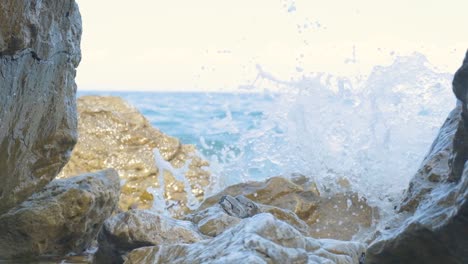 ocean waves crashing and splashing on the rocky beach shore on summer in greece