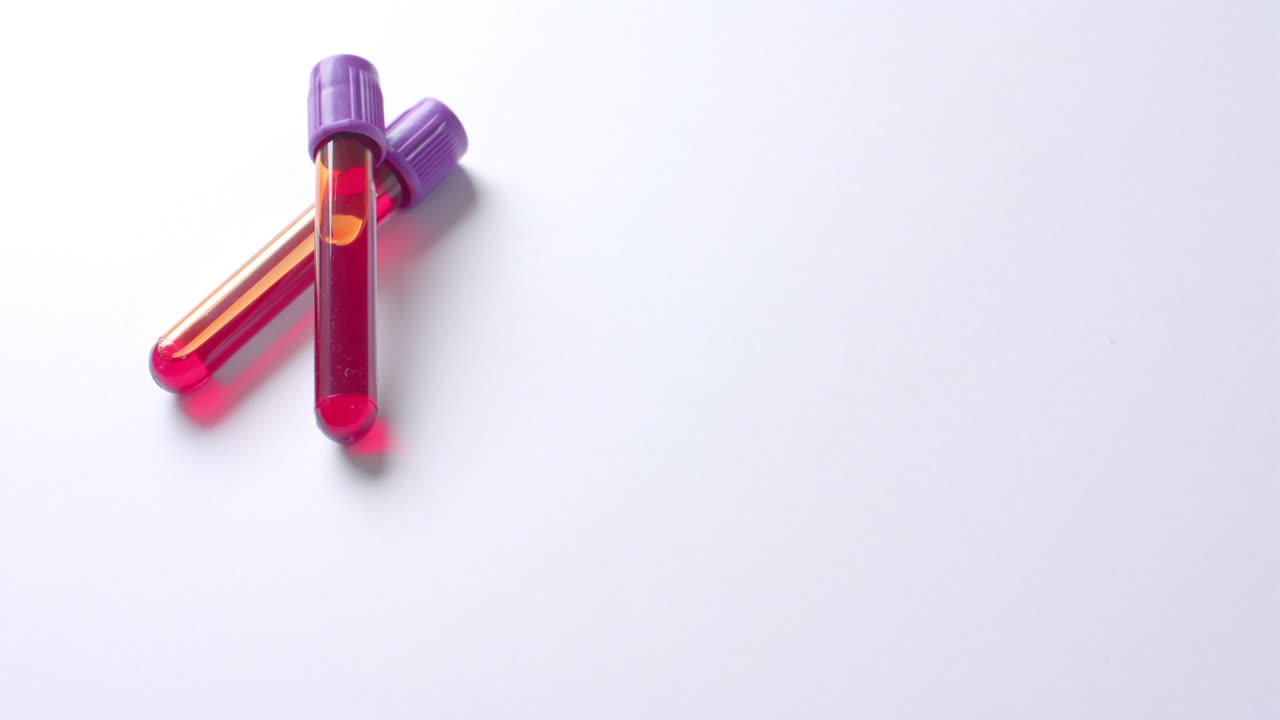 Close up of blood samples on white background with copy space, slow motion