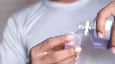 pouring mouthwash into a cup