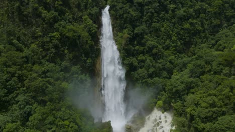 cascading tall waterfall in green jungle rainforest of veracruz, mexico - aerial