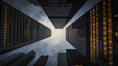 business and finance concept, zoom out timelapse view looking up at modern office building architecture at dusk in the financial district of toronto, ontario, canada