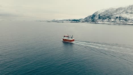 fishing vessel navigating in the fjord near lodingen in nordland, norway. - aerial shot