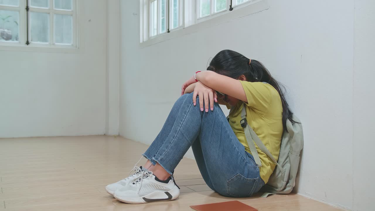 Young Asian Kid Girl Sitting Alone With Sad Feeling At School. Bullying, Discrimination And Racism Concept