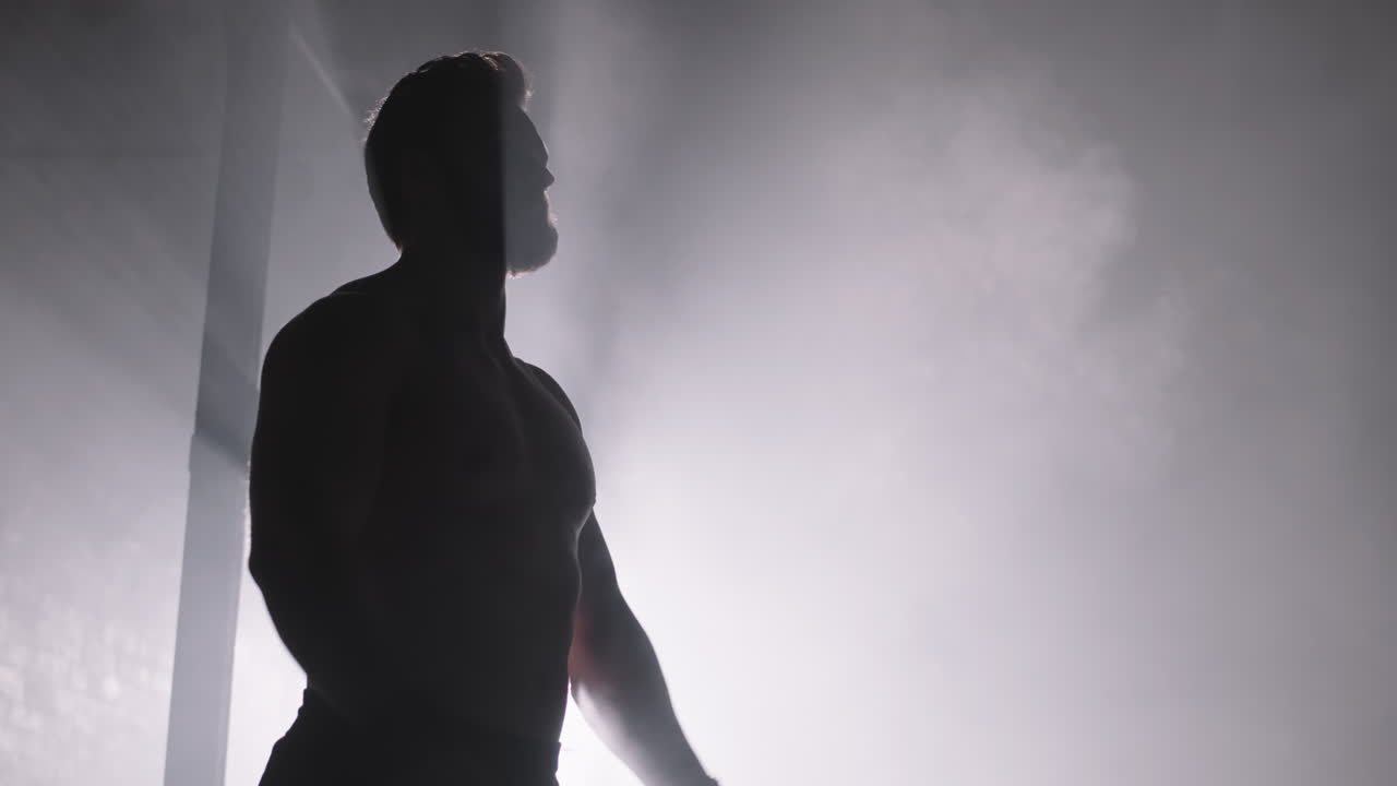 Muscular Man in Darkness in Gym