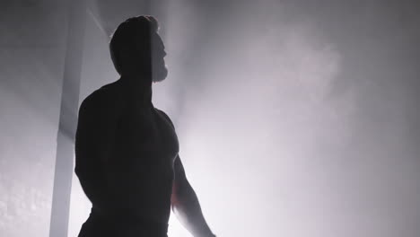 muscular man in darkness in gym
