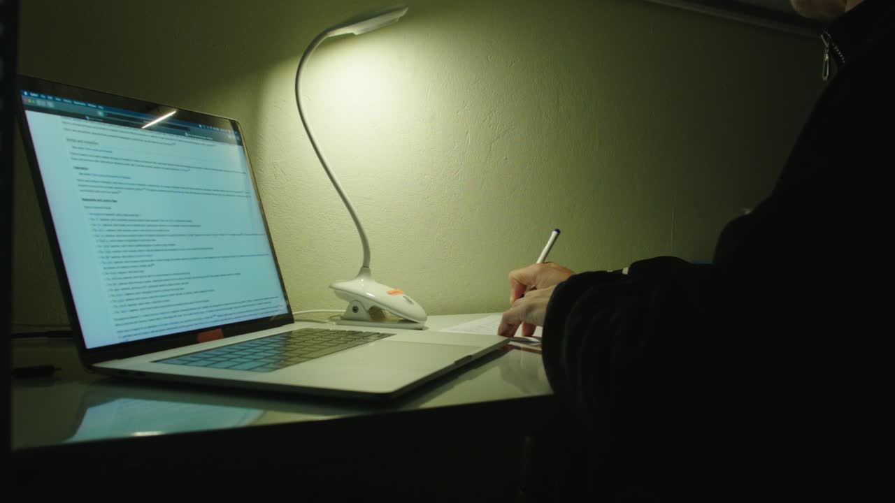 사무실 환경에서 일하는 동안 노트북으로 메모를 하는 사람