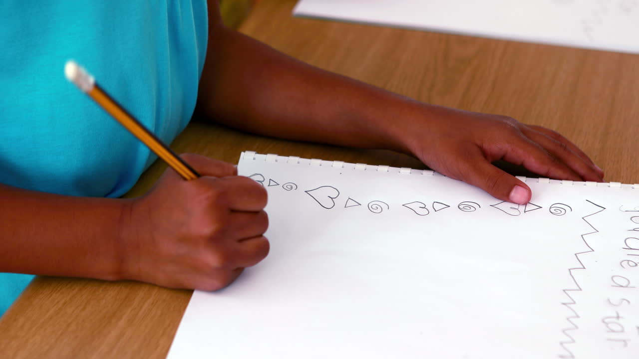 Little boy doodling in white notepad
