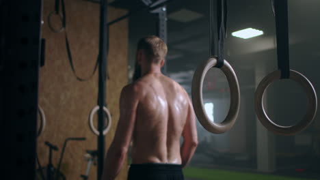 hombres jóvenes agotados descansando después de un entrenamiento intensivo en el gimnasio. atleta masculino agotado está descansando después del entrenamiento. gotas de agua están drenando de su cara entrenamiento en el gimnasio