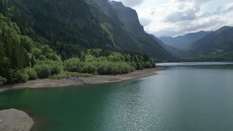 Drone-view-over-the-shores-of-Klöntalersee-Glarus-Kanton-lake,-Switzerland-daytime-shot