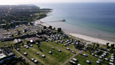 helicopter aerial drone view above campsite campers camping cottages caravan park oldies elderly activity summer beach vacation travel swimming ocean sand cliffs relaxing senior meditation beautiful