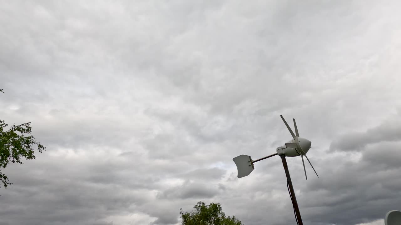 Wind turbine spins steadily in rural Highlands landscape, overcast daylight, static wide shot, natural sound