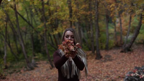 Glückliches-Hübsches-Mädchen-Wirft-Eine-Handvoll-Herbstblätter-In-Den-Park