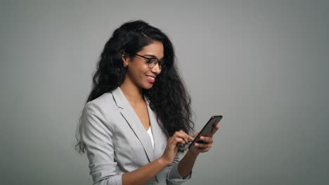 Young-African-businesswoman-uses-a-digital-phone-in-studio-shot