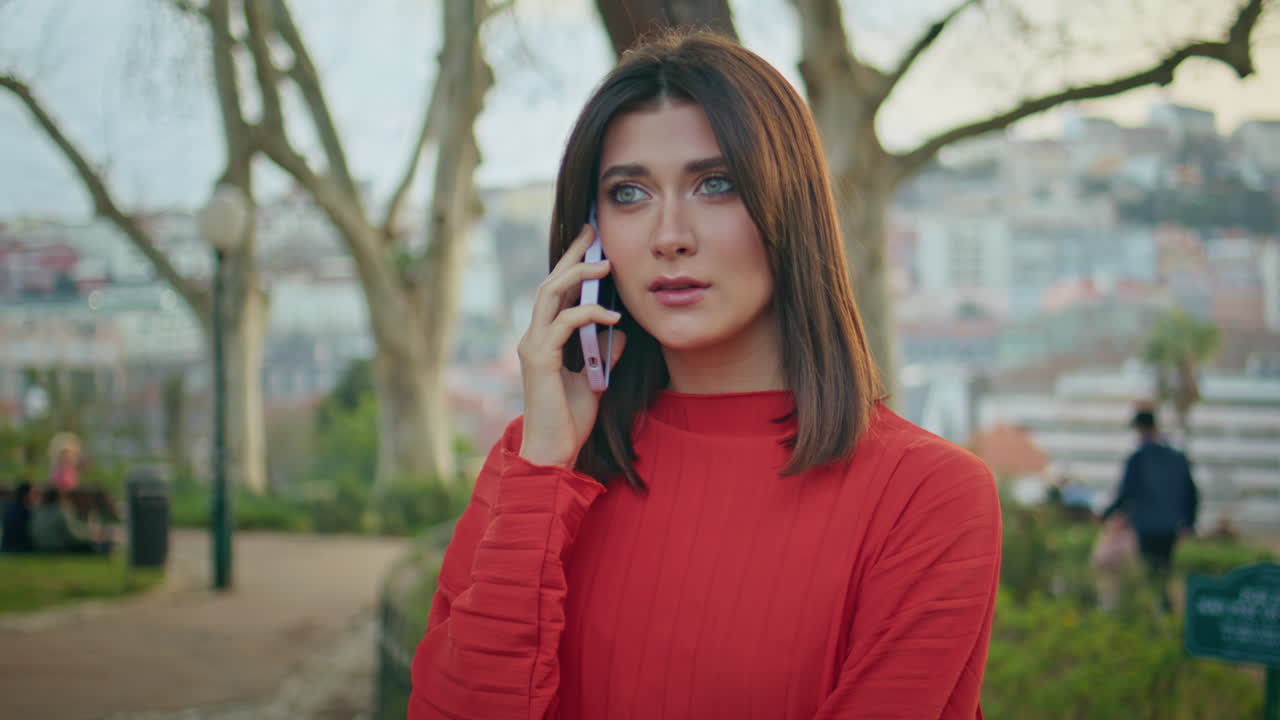 Worried woman calling cellphone cityscape park closeup. Lady talking smartphone