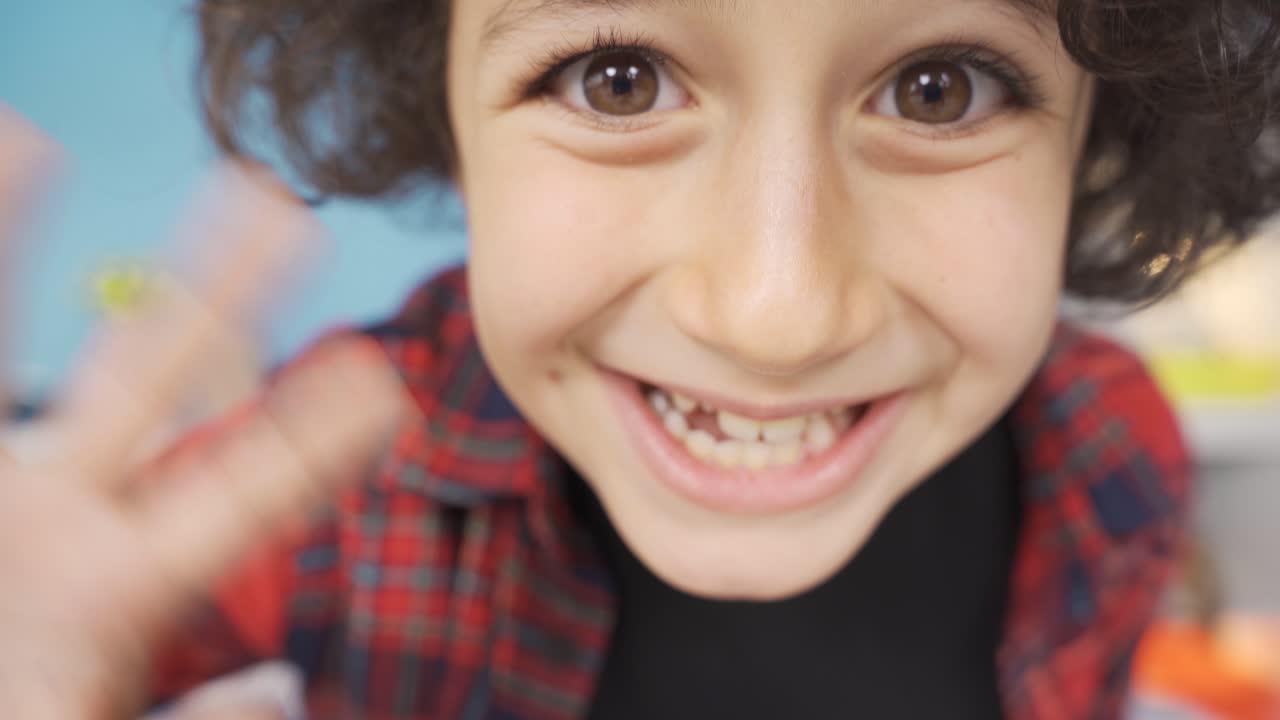 un chico lindo y gracioso saludando.