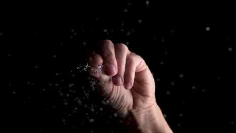 salt being dropped onto a glass surface, underneath angle slow motion