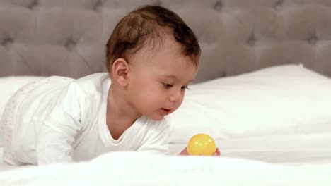 Süßes-Baby,-Das-Mit-Ball-Auf-Dem-Bett-Spielt