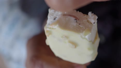 close-up of a person eating a white chocolate ice cream bar