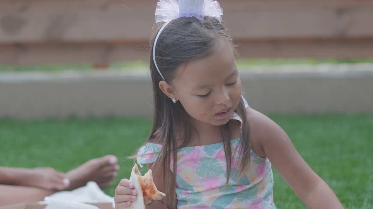 엄마와 어린 딸이 뒷마당에서 담요 위에 앉아 함께 그림을 그리고 있습니다. 야외 장면은 평화로운 가족 순간을 포착하여 창의성과 유대를 촉진합니다.