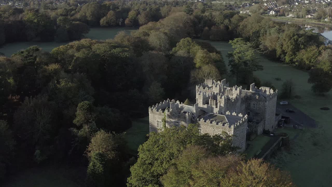 вращающаяся антенна облетает восстановленный ирландский замок с пышной зеленой территорией
