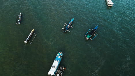 -Indonesian-fisherman-boats-in-the-waves-of-Kuta-Mandalika,-aerial