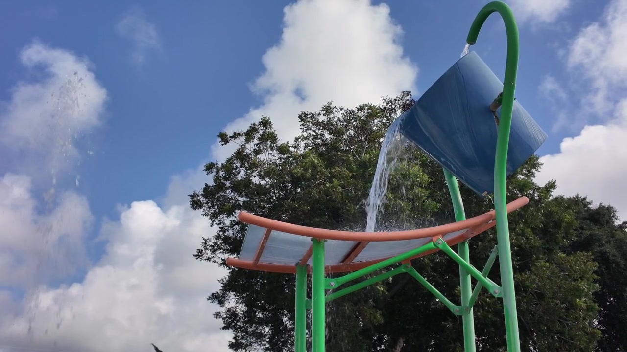 Elementos aquáticos interativos operam em um parque aquático infantil sem visitantes, criando uma cena de verão em uma área de lazer pública