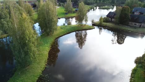 Fishing-Pond-in-Small-Town-of-Blome,-Latvia---Establishing-Aerial