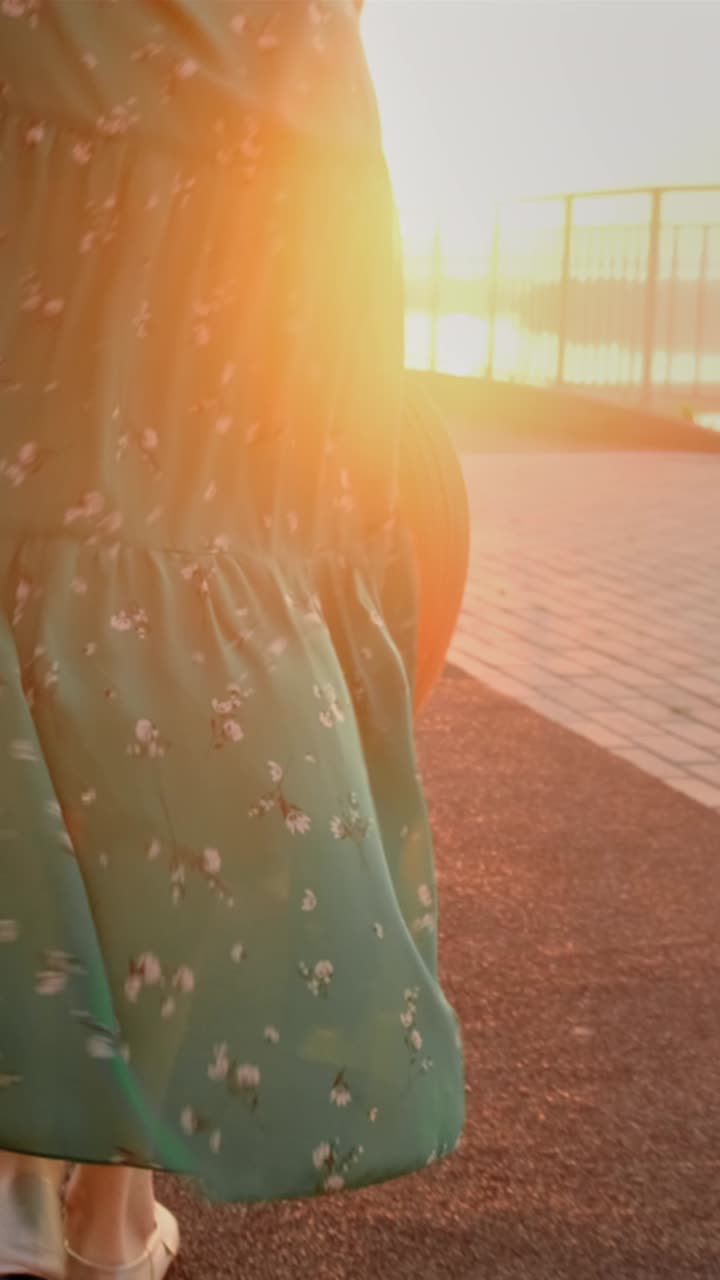 Woman in a green floral dress and a straw hat