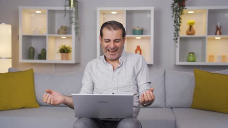 hombre mirando la computadora portátil haciendo un gesto positivo.