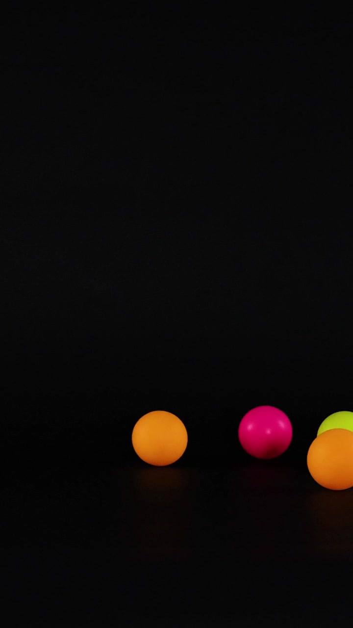 Vibrant balls moving across a dark background