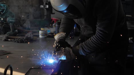 welder on the table welds a set of metal parts