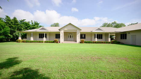 large house with expansive green lawn and blue sky