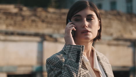 Mujer-Elegante-Haciendo-Una-Llamada-De-Negocios-Al-Aire-Libre.