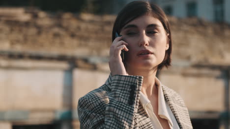 una mujer elegante haciendo una llamada de negocios al aire libre.