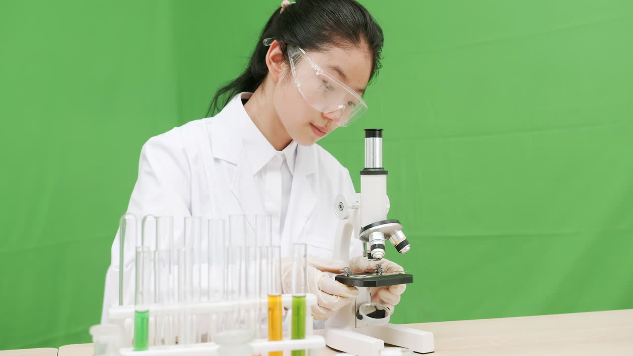 Young scientist examining samples with a microscope in a laboratory setting