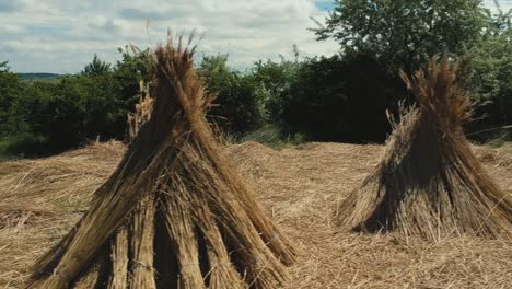 panning low altitude with more closeup areial footage and panning movement from the pile of straws near the main countryside road