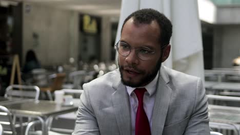 confident bearded businessman talking with partner at cafe