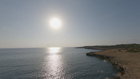 ocean sun beam aerial follows rugged limestone cliffs