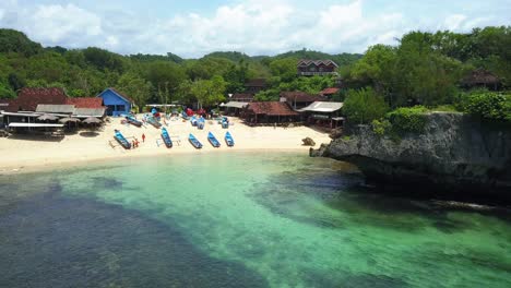 Vista-Aérea-De-La-Exótica-Playa-De-Arena-Con-Botes-Y-Arrecifes-De-Coral-En-La-Jungla-De-Indonesia