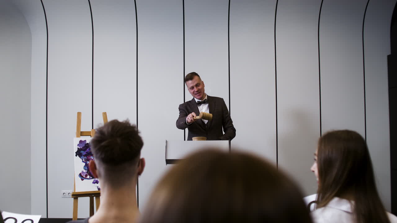 personas en una sesión de subasta de arte