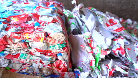 toma cinematográfica de cartones de leche aplanados listos para ser reciclados en bailes de material reciclado