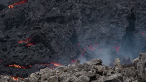 flujo de lava derretida del volcán grindavik en islandia, que muestra grietas brillantes y corteza de lava oscurecida